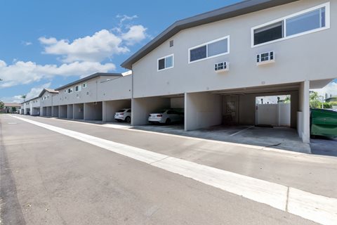 a long white building with cars parked in front of it